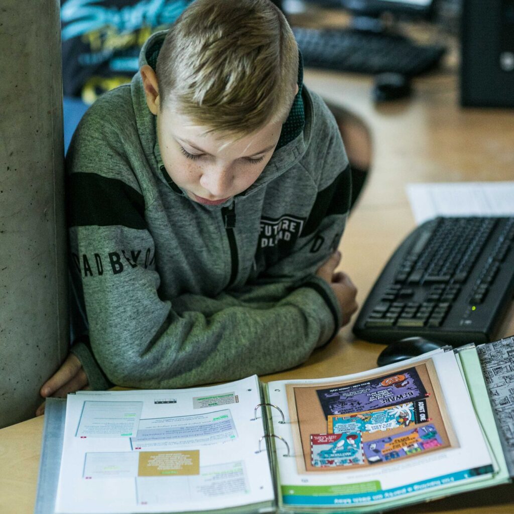 jongen leest geïnteresseerd in zijn lesboek