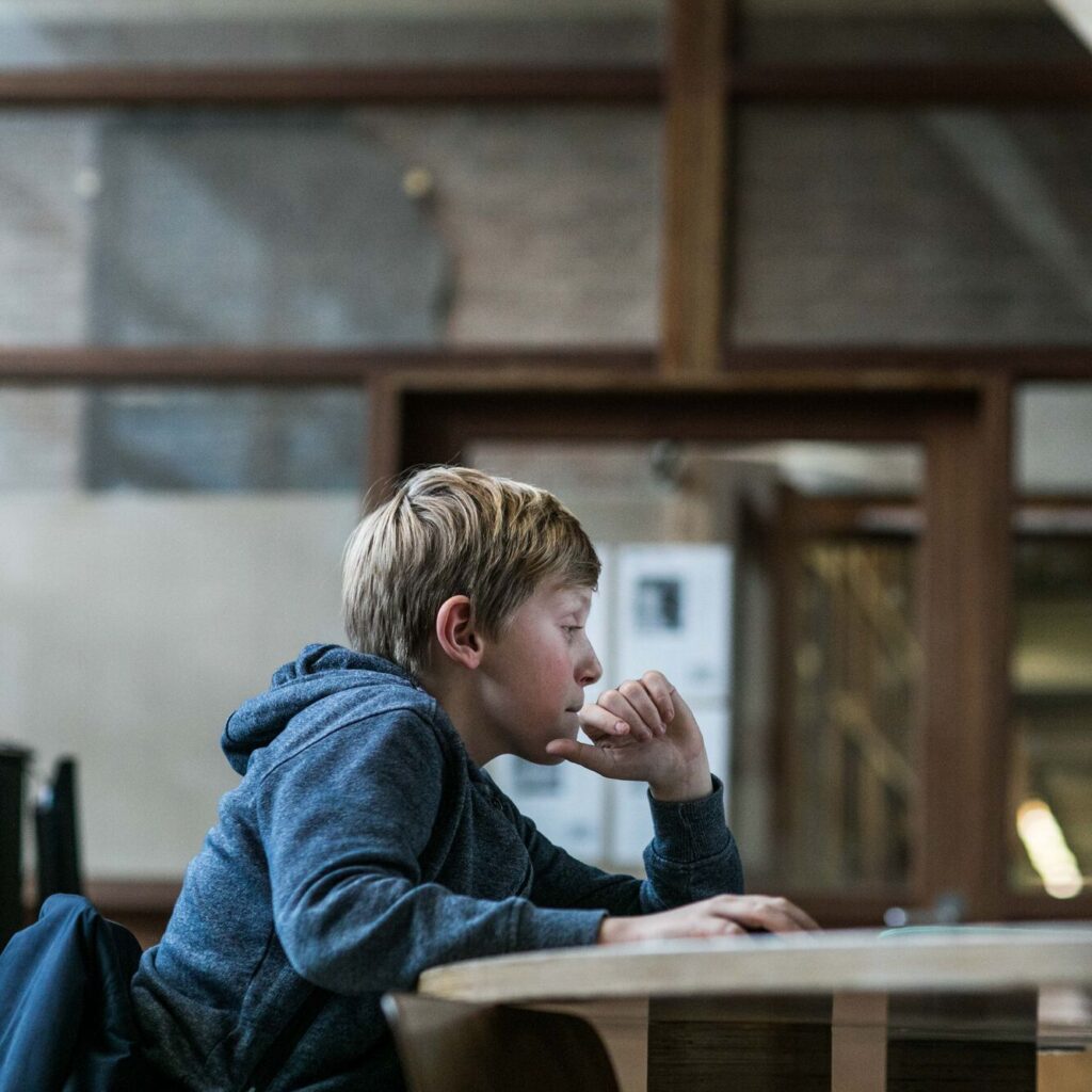 jongen kijkt geïnteresseerd naar een computerscherm