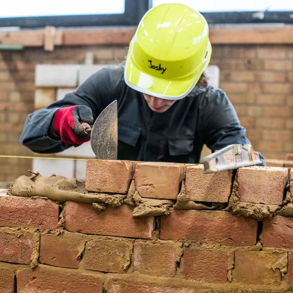 Leerling metst een muur in praktijk bouw