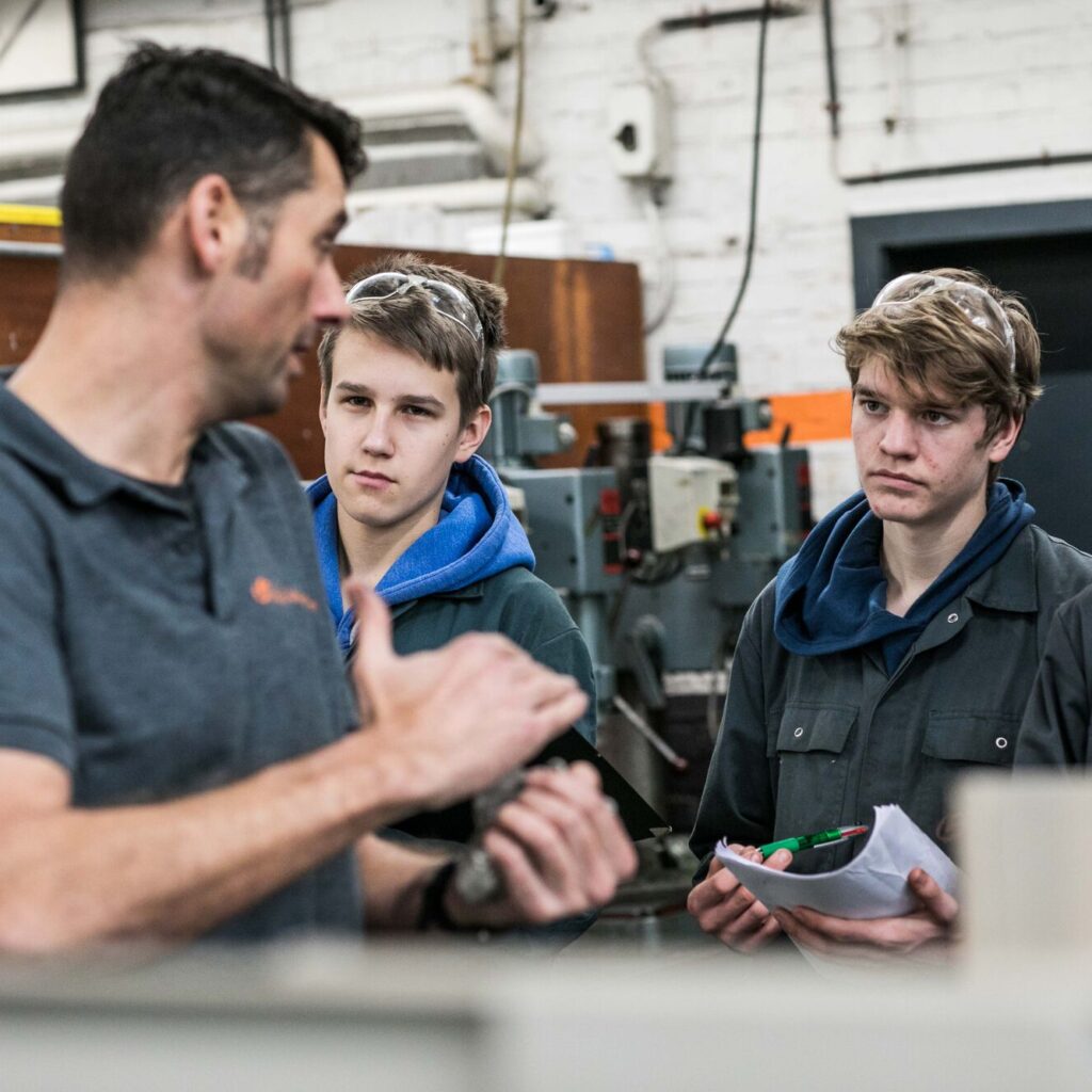 leerlingen luisteren naar leerkracht tijdens praktijk Mechanica