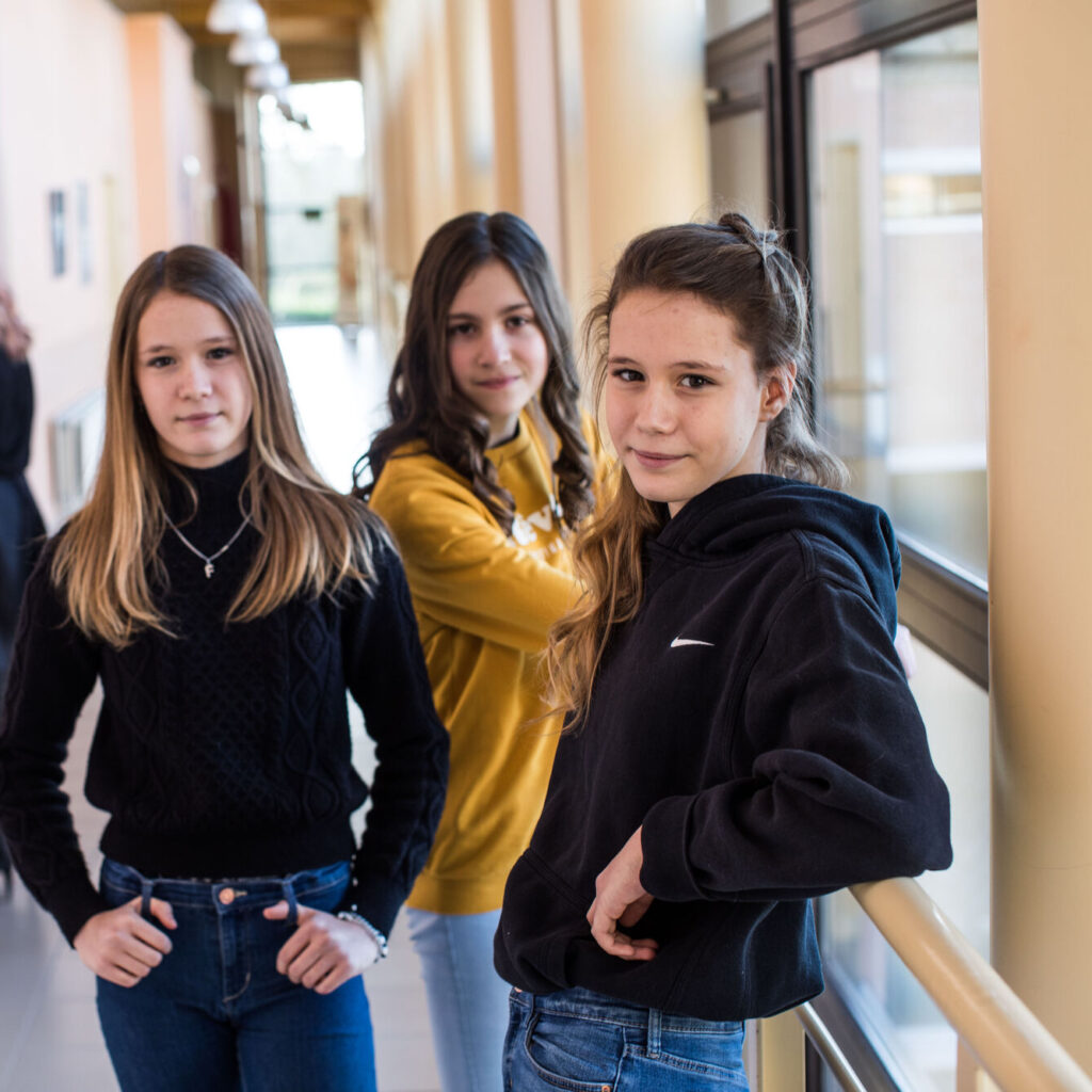 drie leerlingen staan in de gang