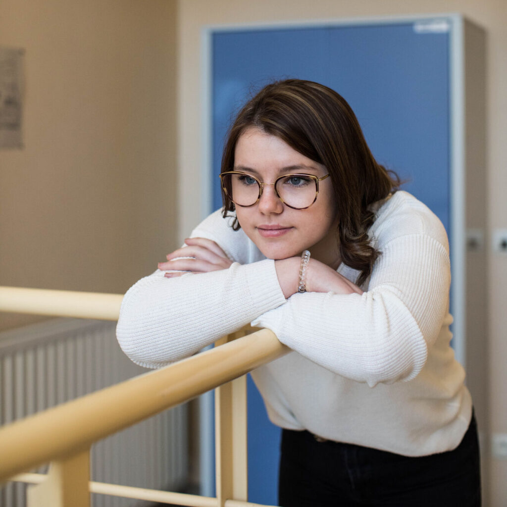 leerling leunt op de leuning en staart voor zich uit