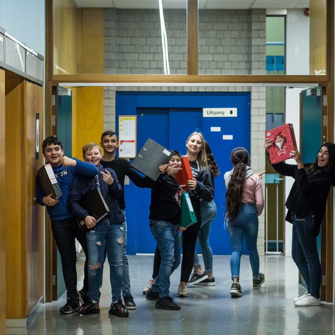 groepje leerlingen staat in de gang en lacht