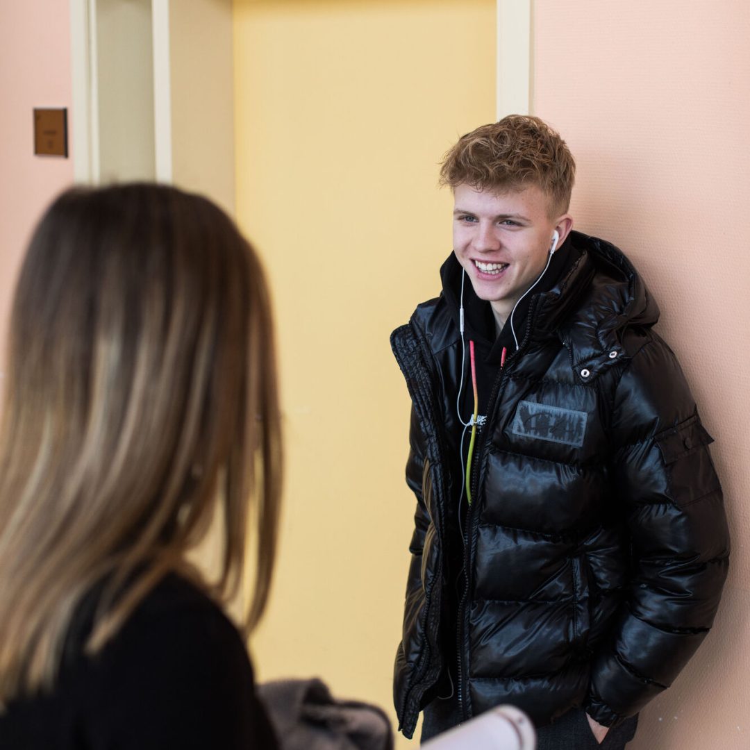 twee leerlingen praten in de gang